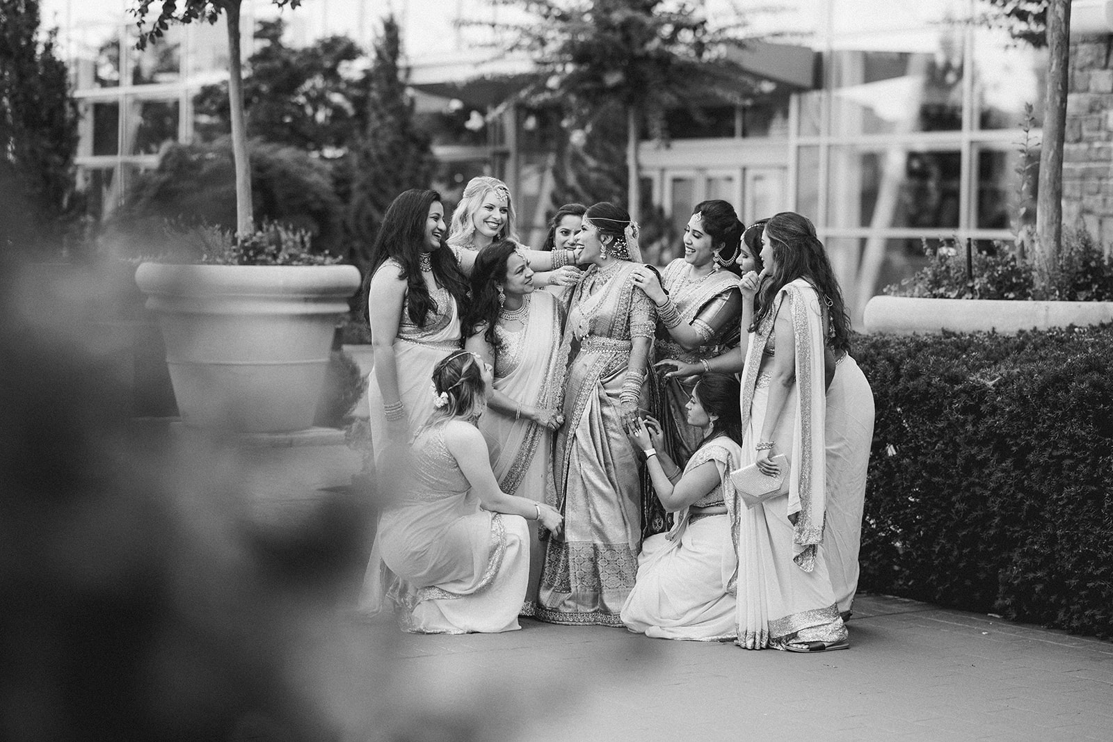 South Asian bridesmaids styled in saree and lehenga posing with the bride